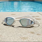 luwa Apex Elite white and silver sport goggles with anti-fog coating and UV protection, resting by a pool.