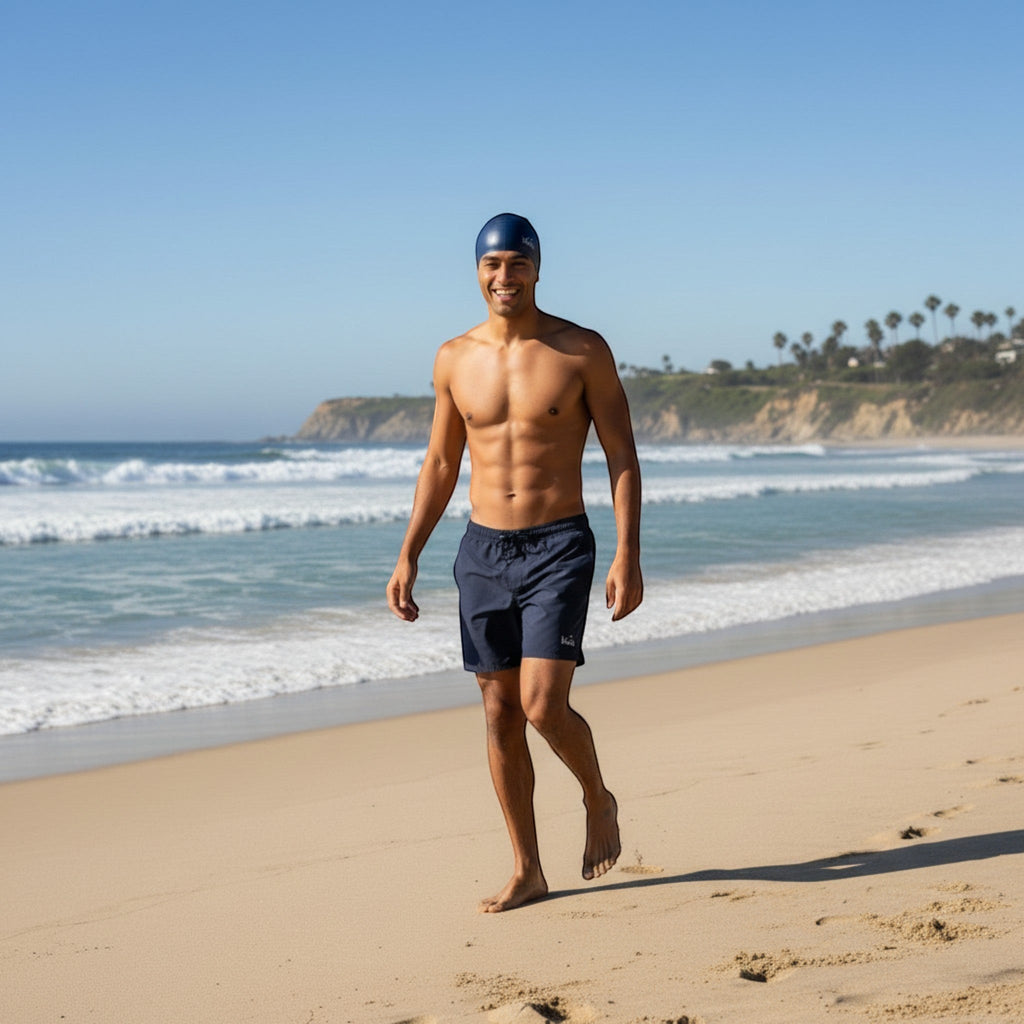 Luwa Apex navy blue silicone swim cap on a man at the beach. Comfortable, durable, and hydrodynamic.