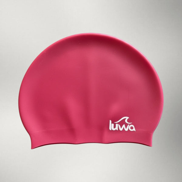 luwa Apex swim cap in bright pink silicone with white logo. Comfortable, durable, and hydrodynamic for training.