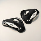 luwa Flow Paddles in black and white, designed for swimming training to build arm strength and improve technique. Features adjustable straps.