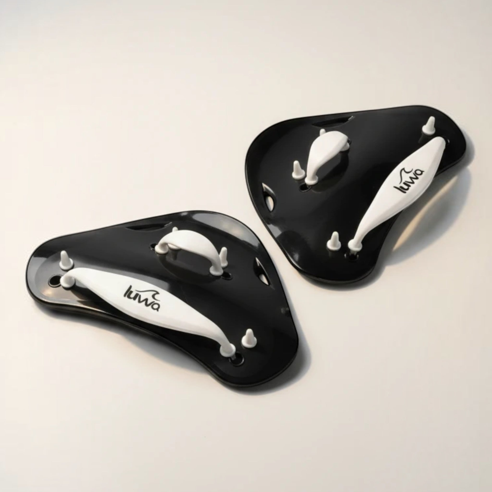 luwa Flow Paddles in black and white, designed for swimming training to build arm strength and improve technique. Features adjustable straps.