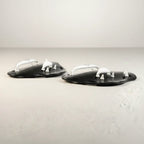 luwa Flow Paddles in black and white, designed for swimming training to build arm strength and refine technique. Features ergonomic shape and adjustable straps.